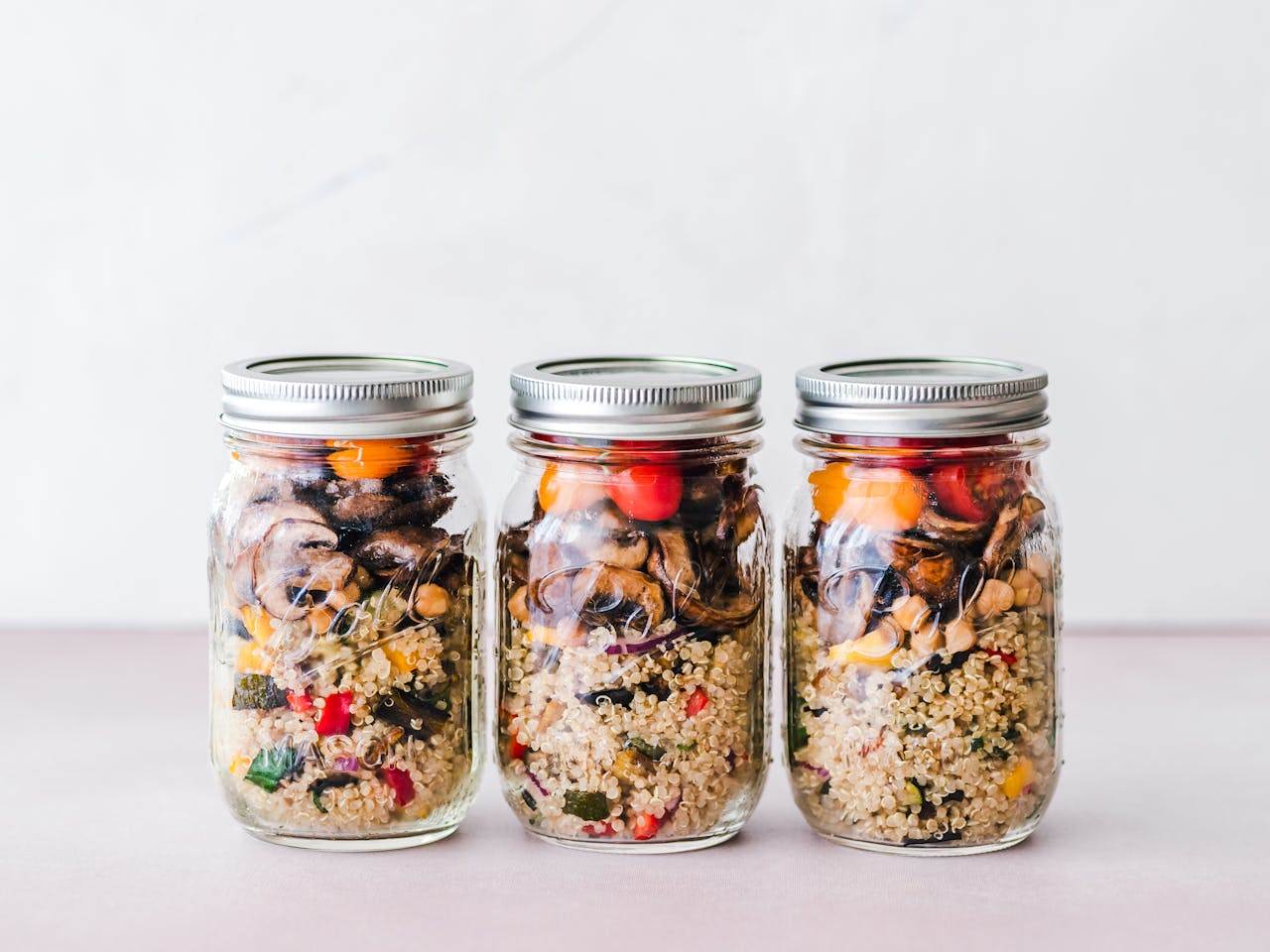 home-hero-1 Colorful quinoa salad jar with roasted veggies, ideal for healthy meal prep.